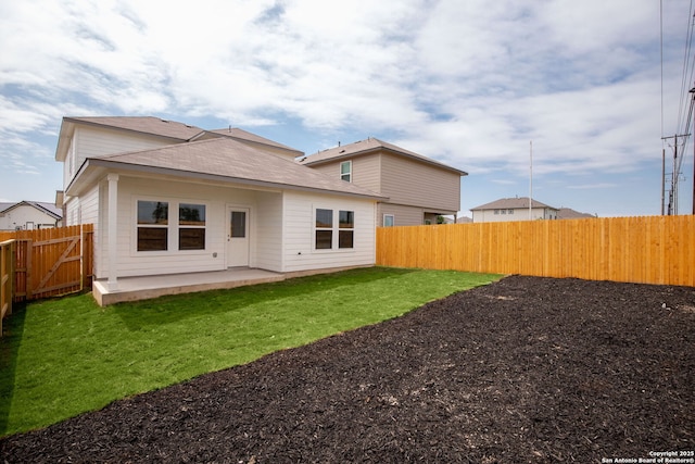 rear view of property with a fenced backyard, a patio, and a lawn