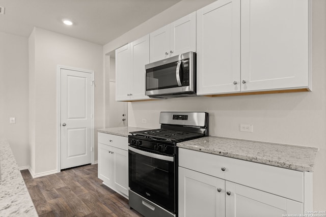 kitchen with recessed lighting, stainless steel appliances, dark wood-style flooring, white cabinetry, and light stone countertops