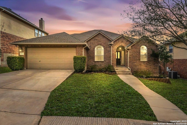 single story home featuring brick siding, concrete driveway, an attached garage, central AC unit, and a front yard