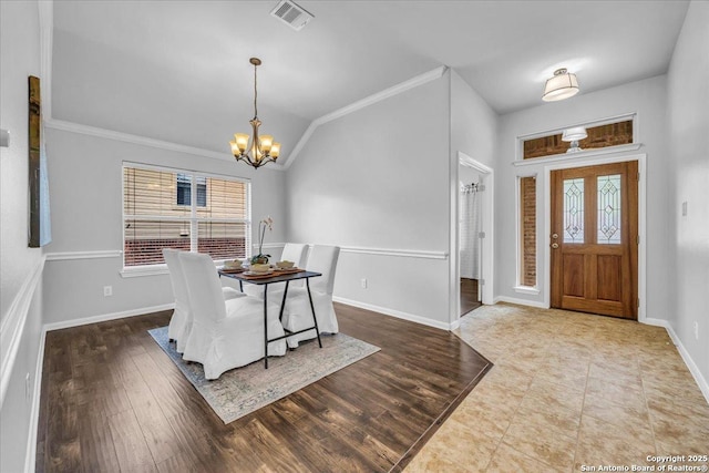 dining space featuring baseboards, visible vents, lofted ceiling, wood finished floors, and an inviting chandelier