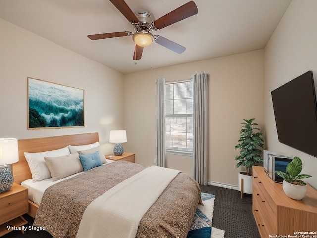 bedroom featuring baseboards, dark colored carpet, and a ceiling fan