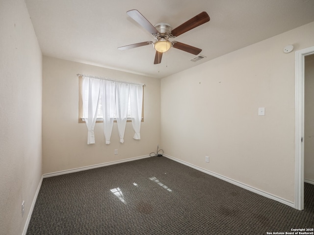 empty room with ceiling fan, dark carpet, visible vents, and baseboards