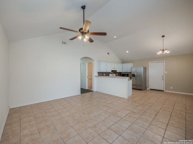 kitchen with ceiling fan with notable chandelier, a peninsula, visible vents, white cabinetry, and stainless steel fridge