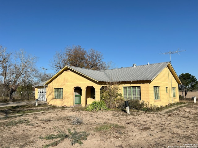 ranch-style home with a garage and metal roof