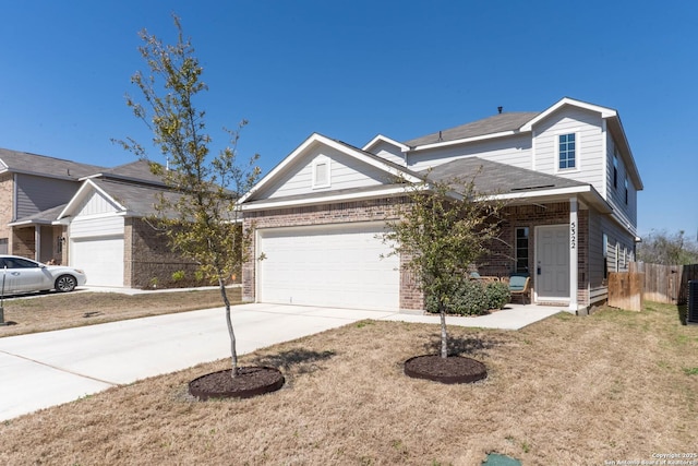 traditional-style home with an attached garage, fence, concrete driveway, and brick siding