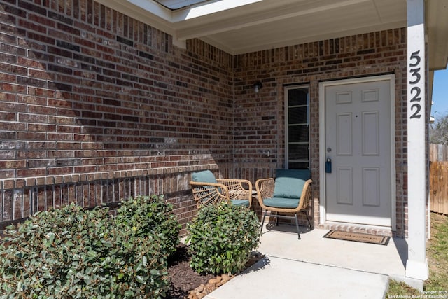 entrance to property featuring brick siding