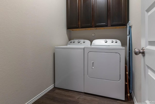 clothes washing area with cabinet space, washing machine and dryer, dark wood-style floors, and baseboards