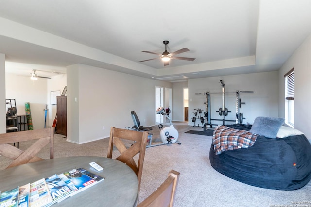 interior space featuring plenty of natural light, a tray ceiling, ceiling fan, and carpet flooring