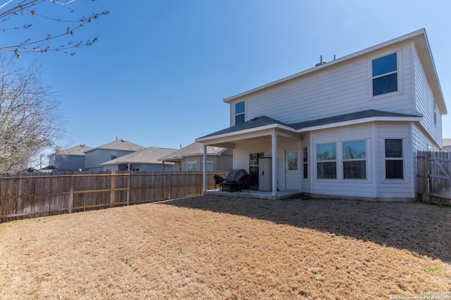 back of property featuring a yard, a patio area, and a fenced backyard