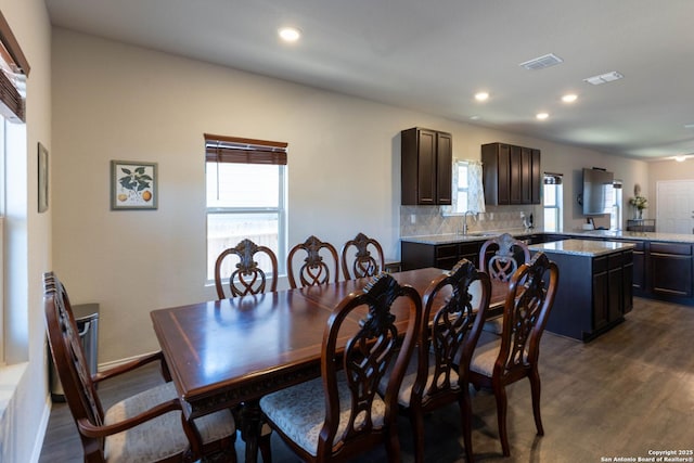 dining room with a healthy amount of sunlight, dark wood-style floors, and visible vents