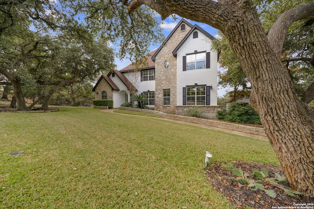 view of front facade featuring stone siding and a front lawn