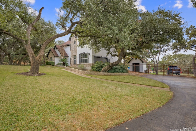 view of front facade with a front lawn, fence, and stucco siding