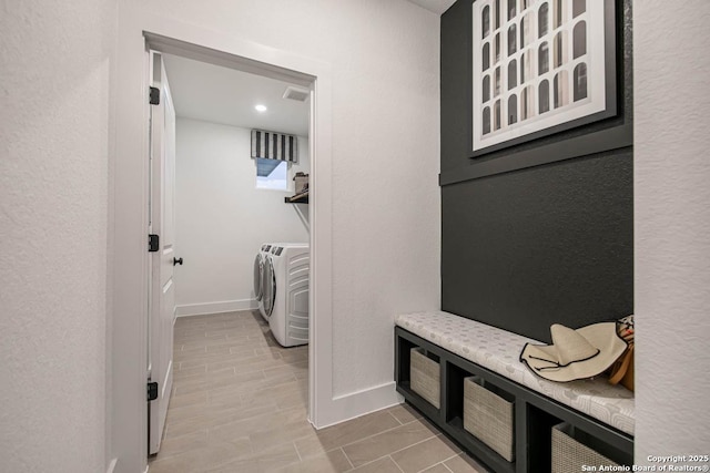 laundry room featuring laundry area, washing machine and dryer, visible vents, and baseboards