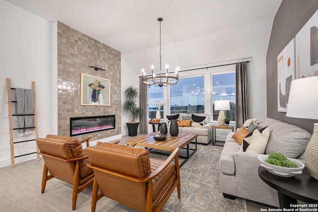 living room with a tile fireplace, lofted ceiling, and an inviting chandelier