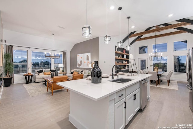 kitchen with lofted ceiling with beams, stainless steel appliances, light countertops, a chandelier, and a sink