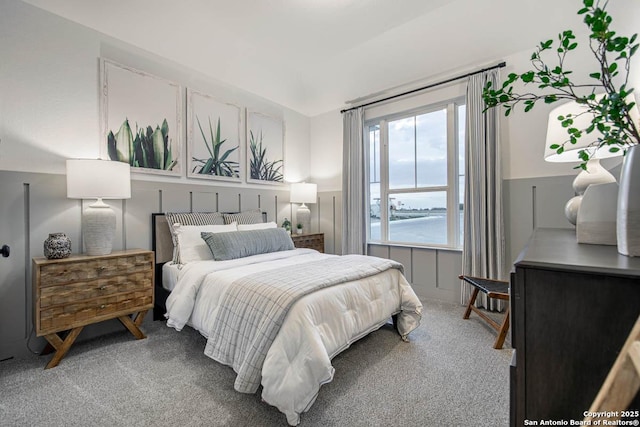 bedroom featuring a decorative wall and carpet flooring