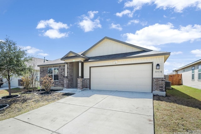 view of front facade featuring an attached garage, fence, concrete driveway, and brick siding