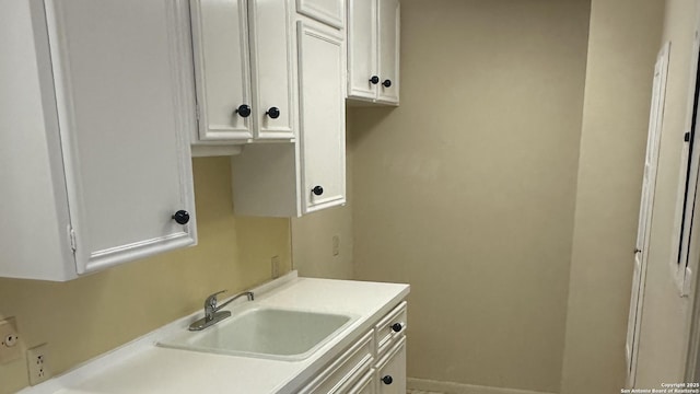 laundry room with a sink and baseboards