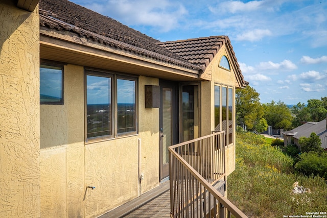 view of property exterior featuring a tiled roof and stucco siding