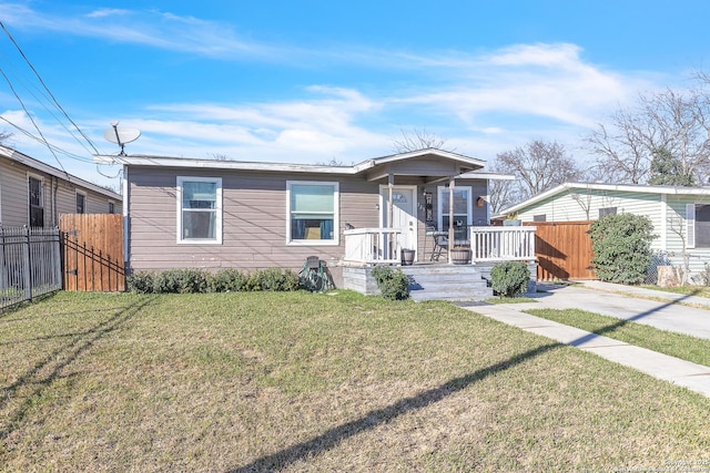 view of front of home with a front yard and fence