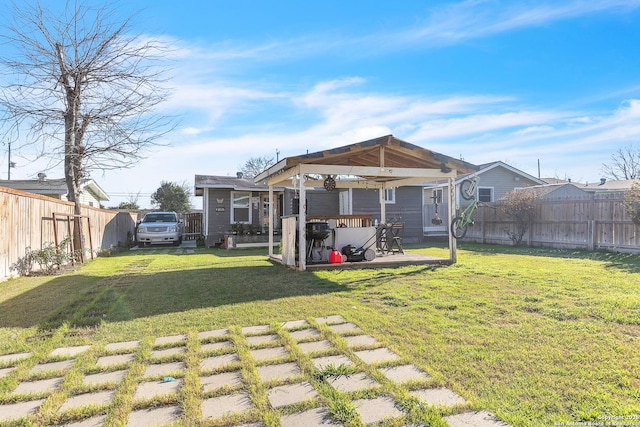 rear view of house with a fenced backyard, a lawn, and a gazebo