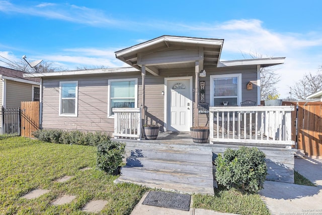 view of front of home featuring fence and a front lawn