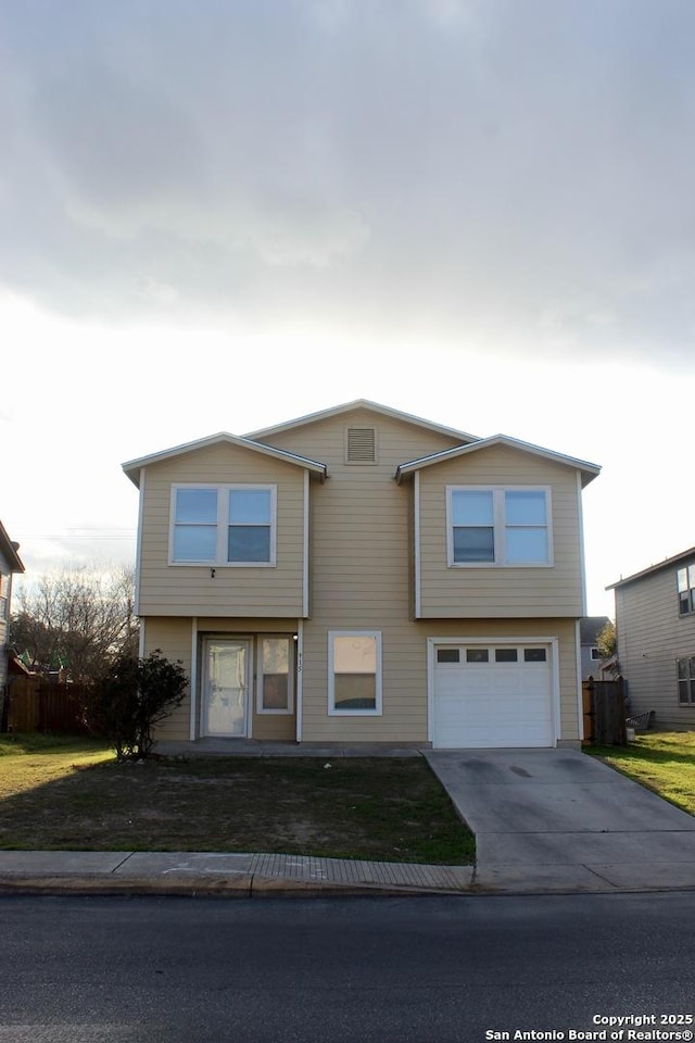 view of front of house featuring driveway, an attached garage, fence, and a front yard