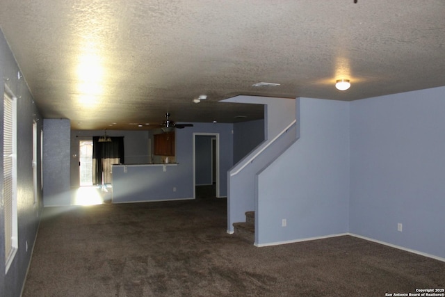 915 Ridingate Farm, San Antonio, TX 78228 - unfurnished living room with baseboards, carpet flooring, stairway, and a textured ceiling