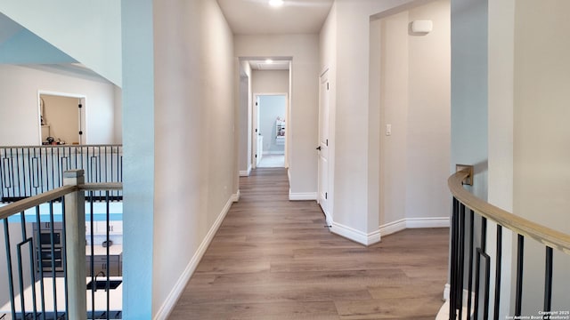 hall featuring baseboards and wood finished floors