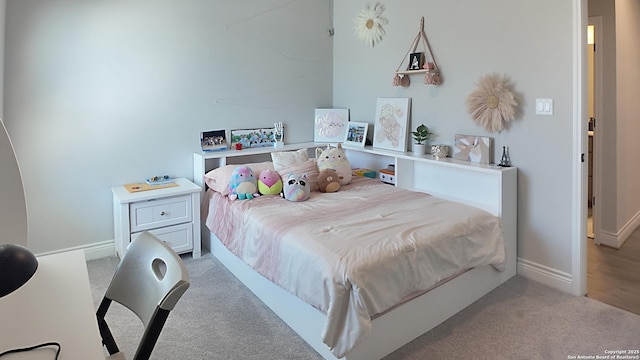 bedroom featuring light carpet and baseboards