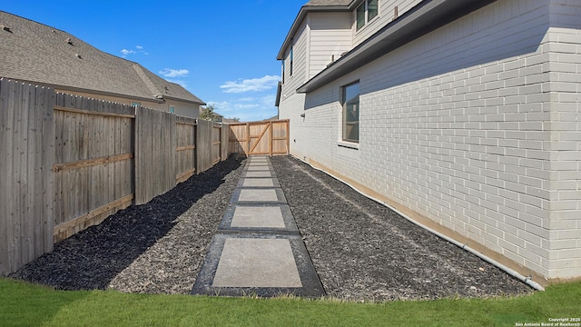 view of yard featuring a fenced backyard and a gate