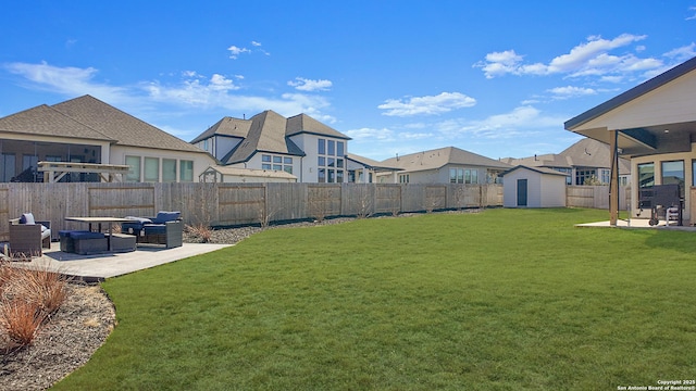 view of yard featuring an outbuilding, a fenced backyard, an outdoor hangout area, a shed, and a patio area