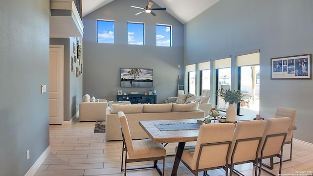 dining space with a ceiling fan, wood finish floors, vaulted ceiling, and baseboards