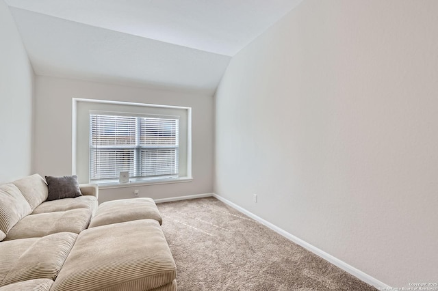 living room with vaulted ceiling, baseboards, and light colored carpet