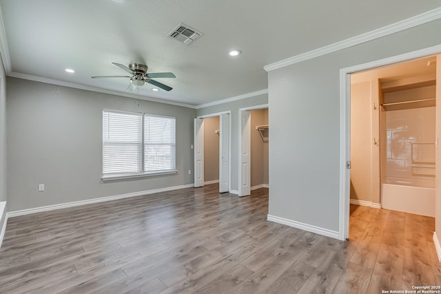 unfurnished bedroom with ornamental molding, light wood finished floors, visible vents, and baseboards