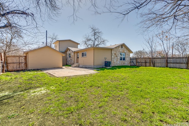 back of property featuring central AC, a patio, a lawn, and a fenced backyard