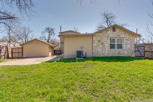 rear view of house with driveway, a gate, fence, and a yard