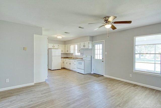 kitchen featuring white appliances, baseboards, visible vents, and light wood finished floors