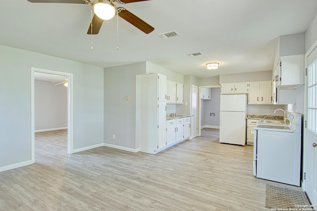 kitchen with visible vents, stove, light countertops, and freestanding refrigerator