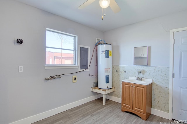 bathroom featuring electric water heater, ceiling fan, vanity, wood finished floors, and electric panel