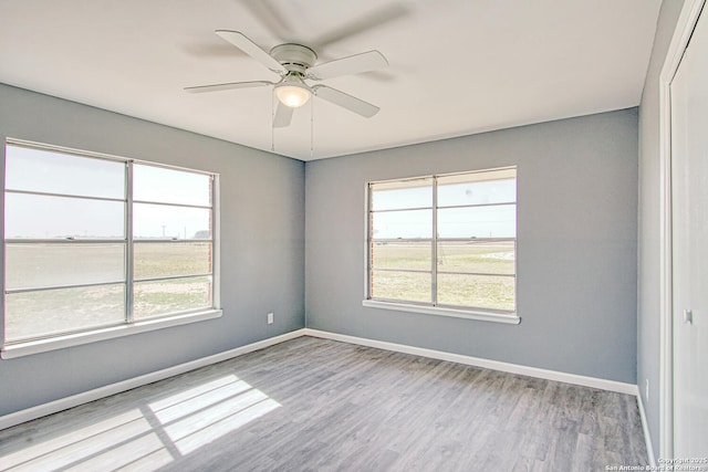 unfurnished room featuring ceiling fan, wood finished floors, and baseboards