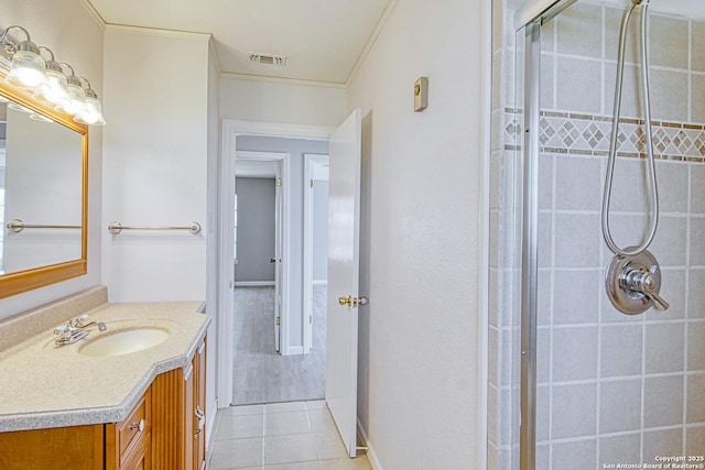 full bath with visible vents, tiled shower, tile patterned flooring, crown molding, and vanity