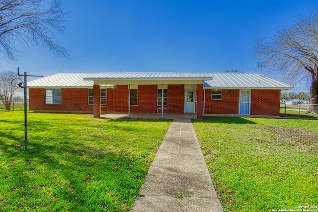 ranch-style home featuring metal roof, a front lawn, fence, and brick siding