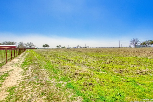 view of yard with a rural view and fence