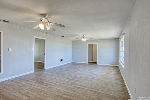 unfurnished room with visible vents, baseboards, and wood finished floors