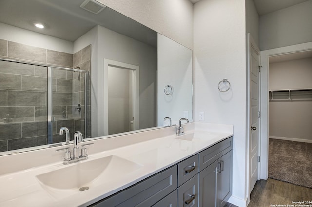 bathroom featuring double vanity, a sink, visible vents, and a shower stall