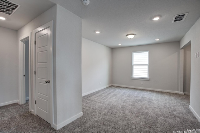 carpeted spare room with recessed lighting, visible vents, and baseboards