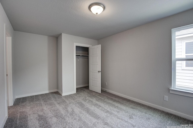 unfurnished bedroom featuring baseboards, multiple windows, and carpet flooring