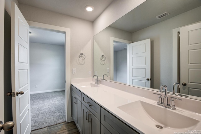 full bathroom featuring double vanity, a sink, visible vents, and baseboards