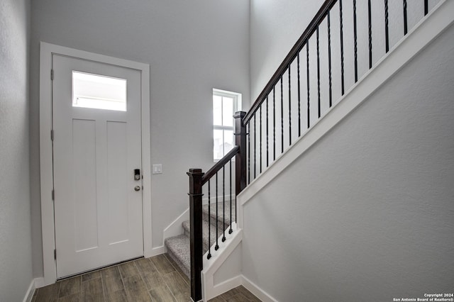 entrance foyer with dark wood-style floors, stairway, and baseboards